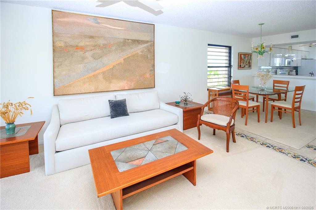 4540 Northeast Sandpebble Trace, Unit 406 Stuart, FL 34996 - Photo 13 of 36 a living room with furniture and a large window