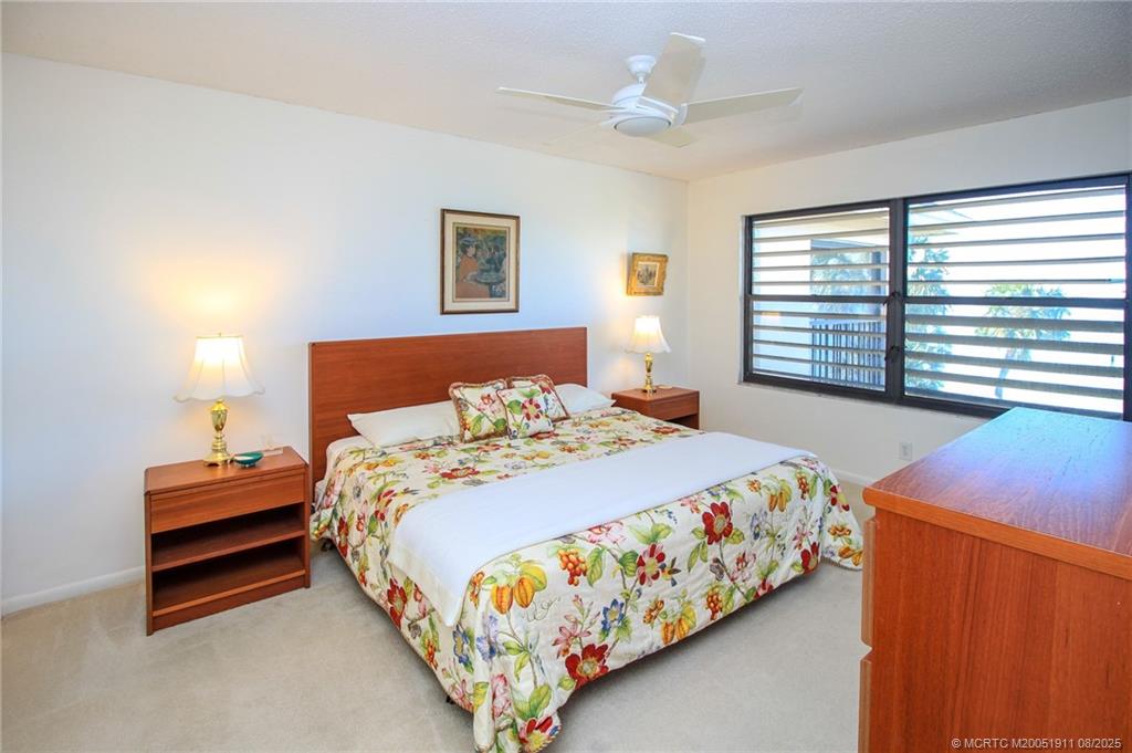 4540 Northeast Sandpebble Trace, Unit 406 Stuart, FL 34996 - Photo 14 of 36 a bedroom with a bed and a window