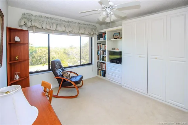 a view of a workspace with furniture and a window