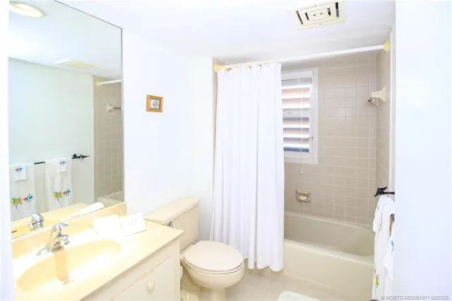 a bathroom with a granite countertop sink a toilet and shower