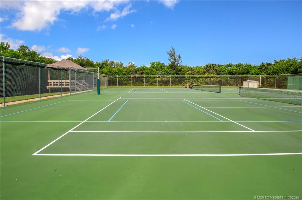 4540 Northeast Sandpebble Trace, Unit 406 Stuart, FL 34996 - Photo 33 of 36 a view of an outdoor space and tennis court