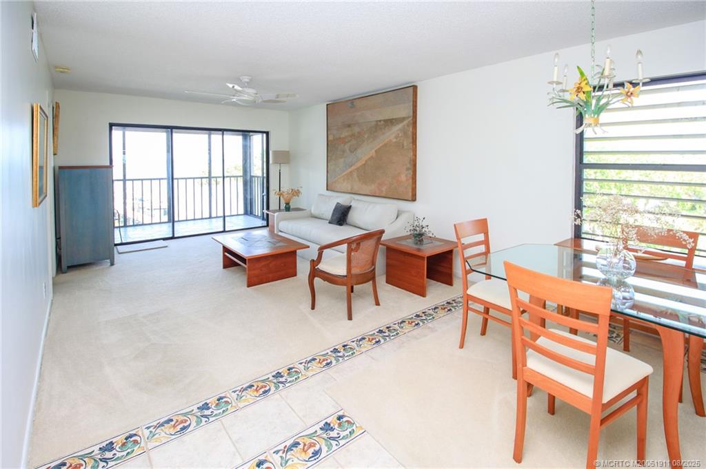 4540 Northeast Sandpebble Trace, Unit 406 Stuart, FL 34996 - Photo 8 of 36 a living room with furniture and a large window