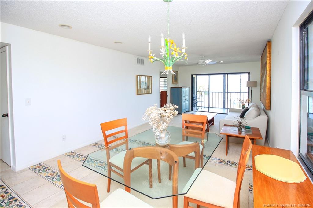 4540 Northeast Sandpebble Trace, Unit 406 Stuart, FL 34996 - Photo 9 of 36 a living room with furniture and a chandelier
