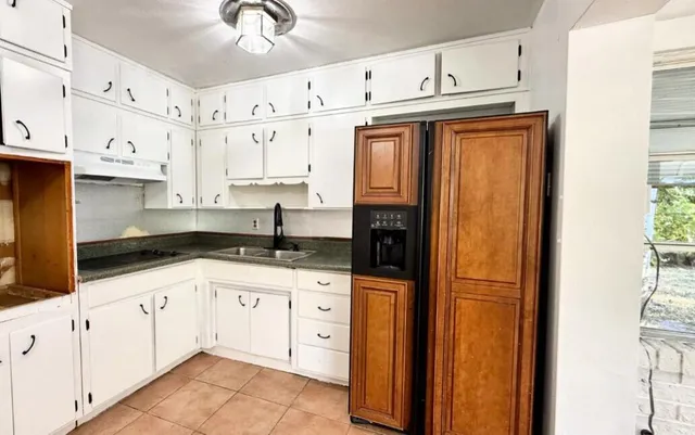 a kitchen with granite countertop a sink a stove and cabinets