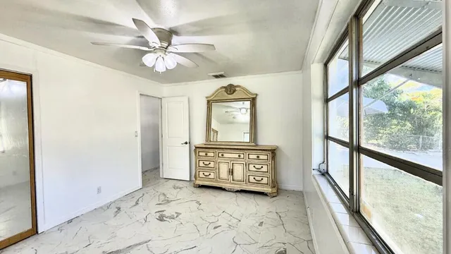 a view of a hallway with wooden floor windows and a ceiling fan