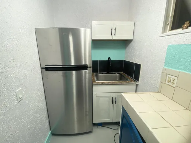 a kitchen with a refrigerator and a stove
