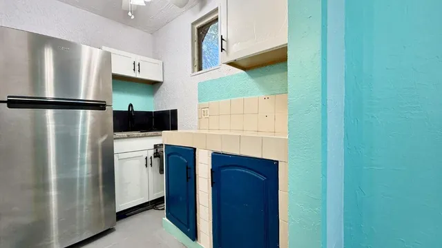a kitchen with stainless steel appliances a refrigerator and a cabinets