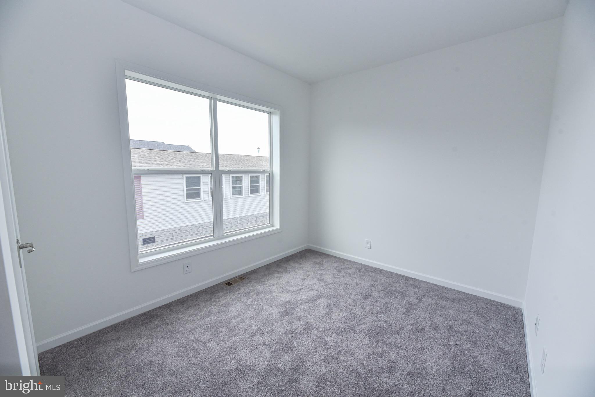 26363 West Pintail Road, Unit 78 Millsboro, DE 19966 - Photo 22 of 40 an empty room with windows