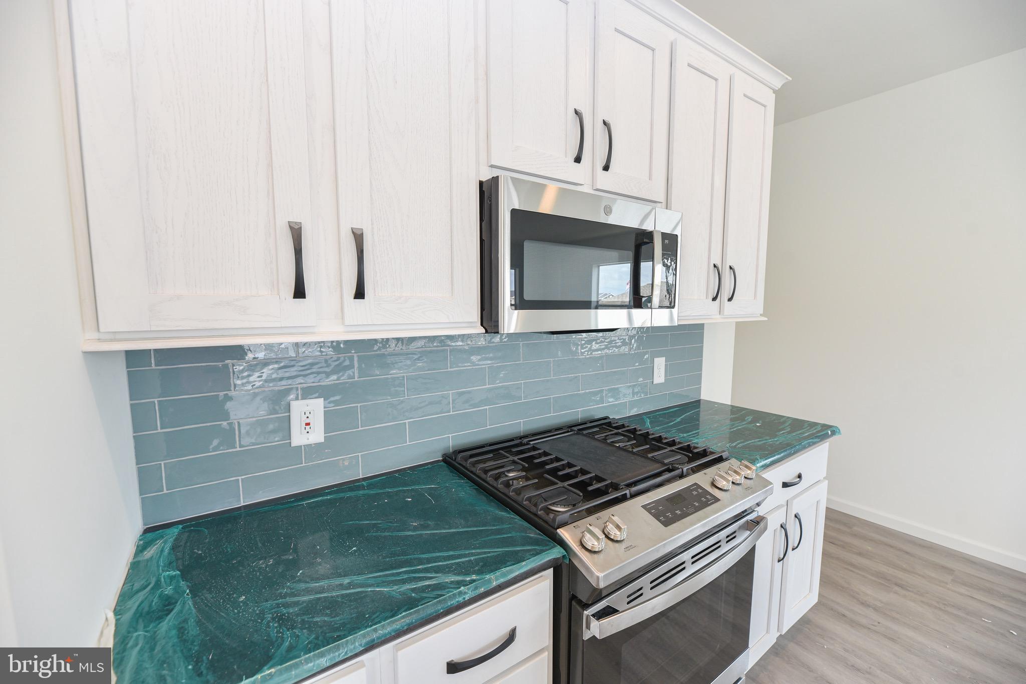 26363 West Pintail Road, Unit 78 Millsboro, DE 19966 - Photo 31 of 40 a stove top oven sitting inside of a kitchen