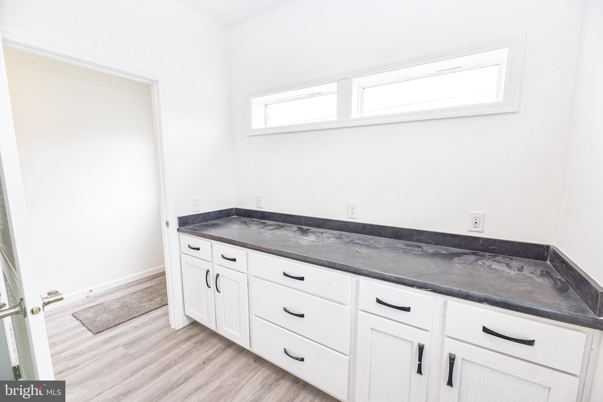 26363 West Pintail Road, Unit 78 Millsboro, DE 19966 - Photo 6 of 40 a view of granite countertop white cabinets and a wooden floor