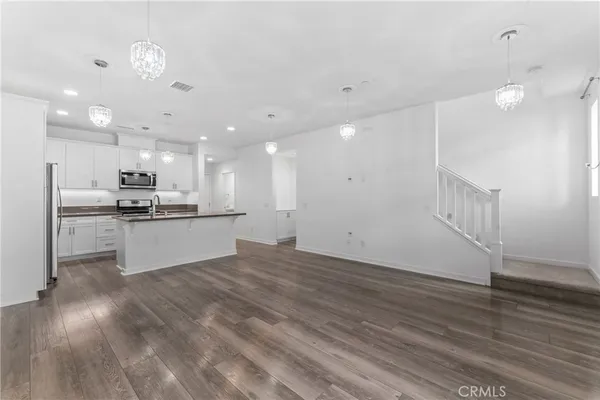 a kitchen with stainless steel appliances granite countertop a sink a stove and a refrigerator