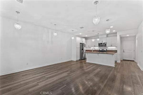 a kitchen with granite countertop white cabinets and stainless steel appliances