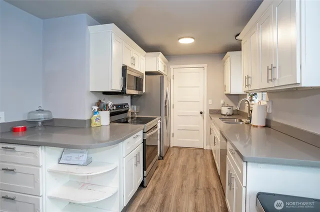 a kitchen with stainless steel appliances granite countertop a sink a stove and cabinets