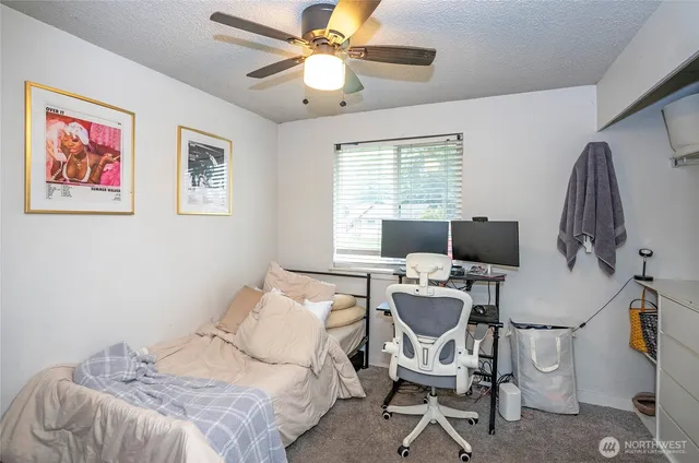 a view of a workspace with furniture and a window