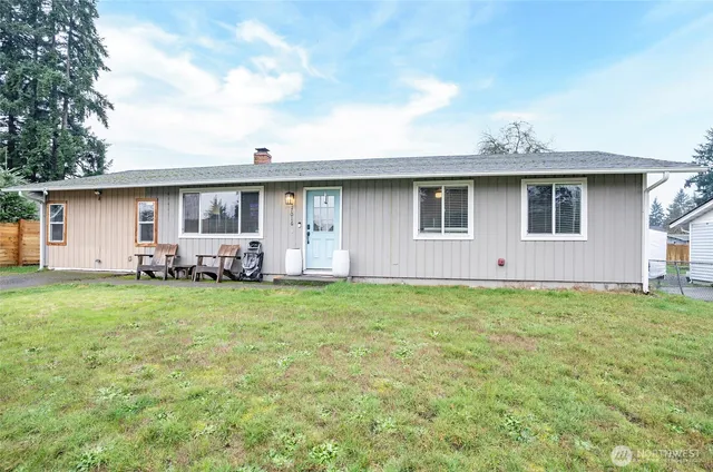 a backyard of a house with table and chairs