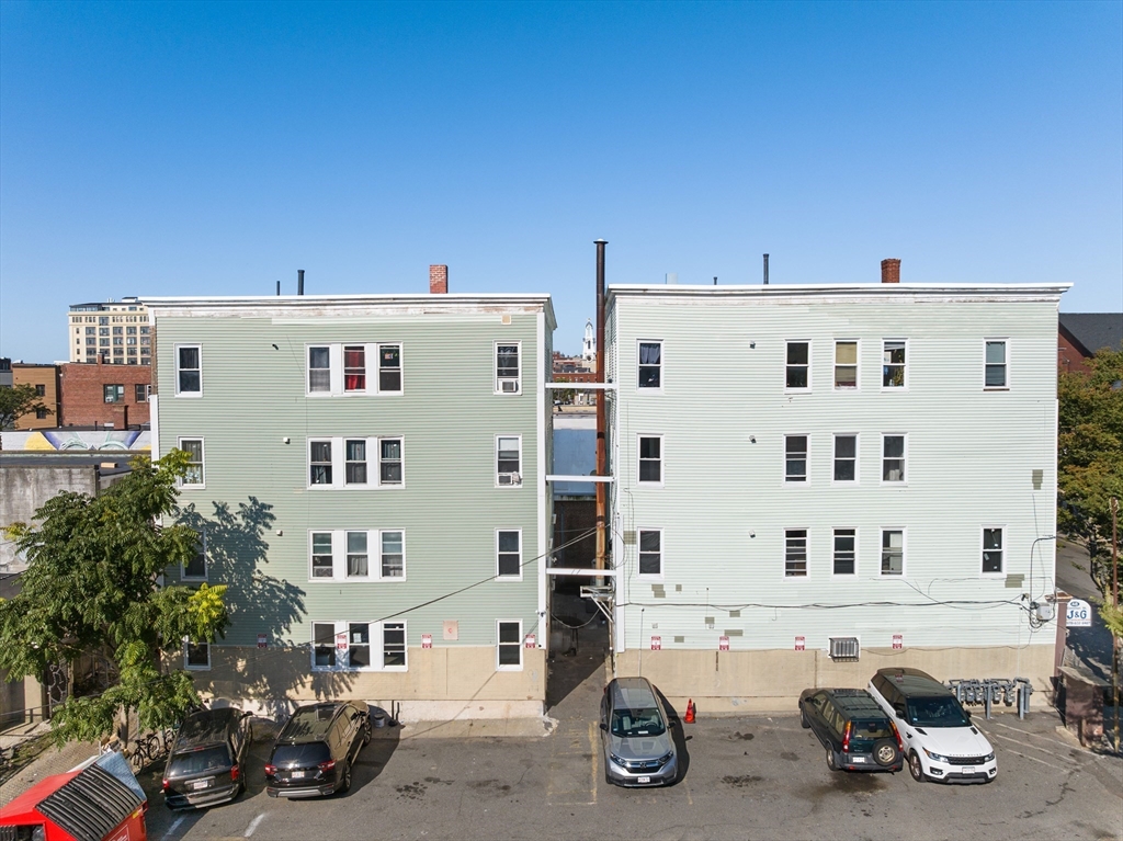 50 Common Street, Unit 5 Lawrence, MA 01840 - Photo 1 of 28 a front view of a building with parking