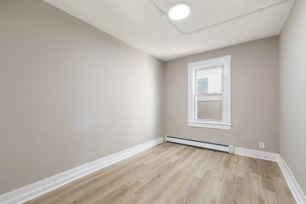 50 Common Street, Unit 5 Lawrence, MA 01840 - Photo 13 of 28 an empty room with wooden floor and windows