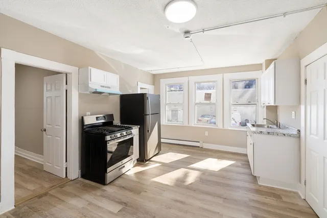a kitchen with granite countertop a refrigerator and a stove top oven