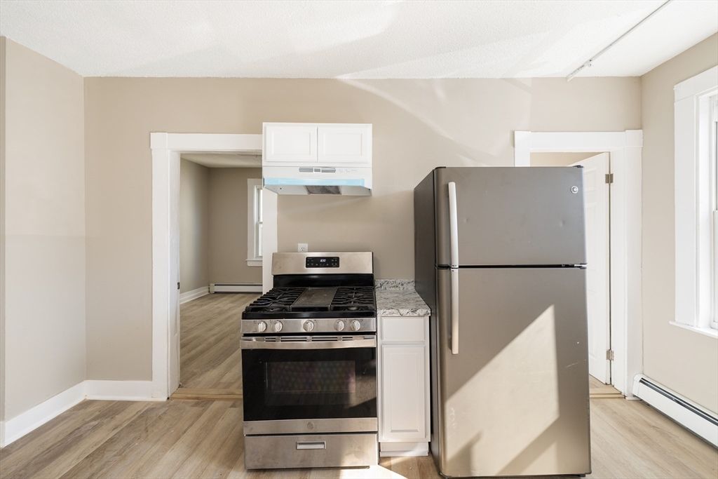 50 Common Street, Unit 5 Lawrence, MA 01840 - Photo 20 of 28 a kitchen with a refrigerator and a stove