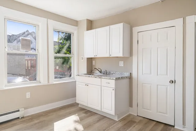 a kitchen with granite countertop white cabinets and window