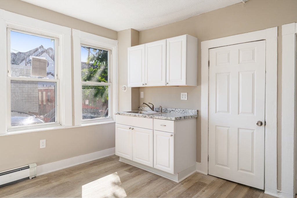 50 Common Street, Unit 5 Lawrence, MA 01840 - Photo 23 of 28 a kitchen with granite countertop white cabinets and window
