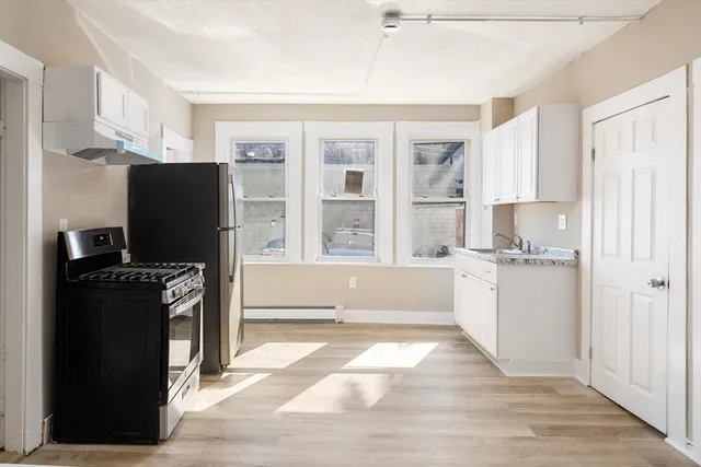 a kitchen with granite countertop a refrigerator and a stove top oven