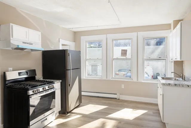 a kitchen with stainless steel appliances granite countertop a refrigerator and a stove top oven