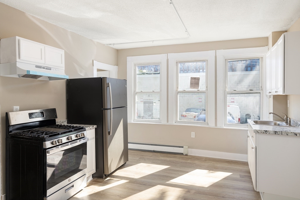 50 Common Street, Unit 5 Lawrence, MA 01840 - Photo 4 of 28 a kitchen with stainless steel appliances granite countertop a refrigerator and a stove top oven