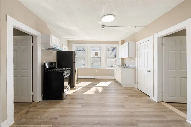 a view of a kitchen with refrigerator and windows