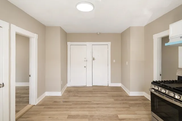 a view of a livingroom with wooden floor and kitchen space