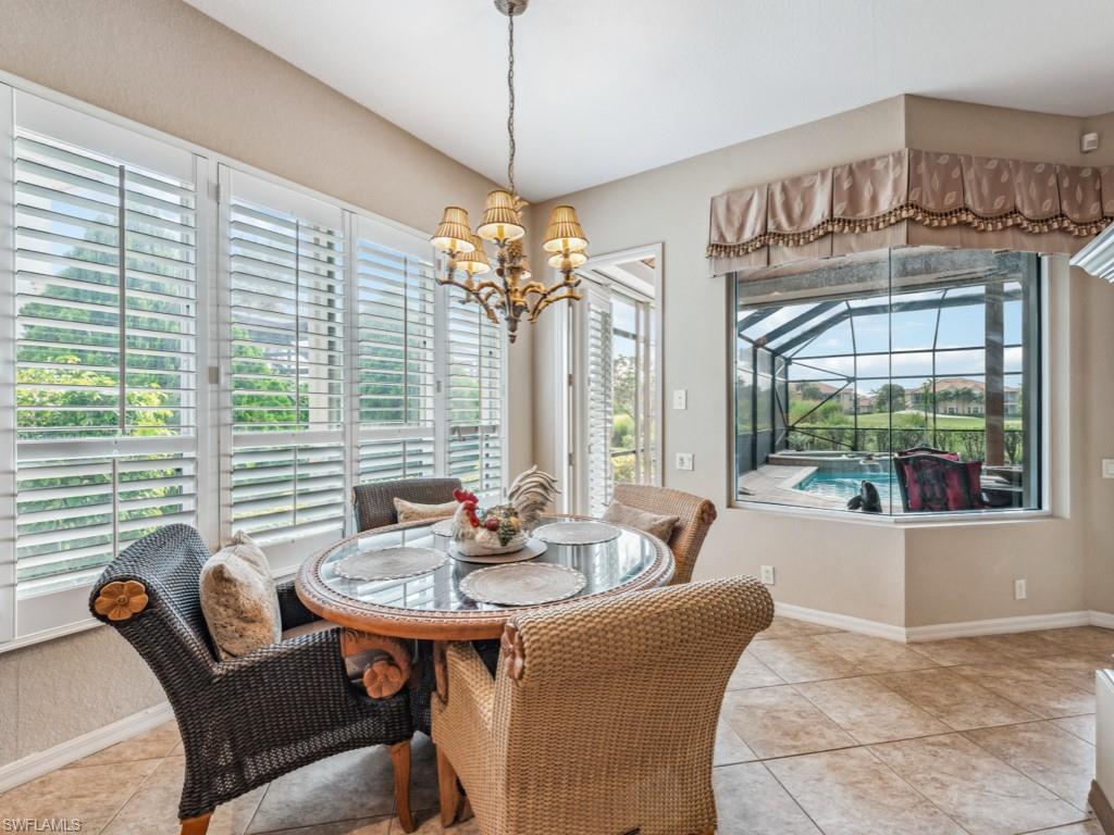 6048 Fairway Court Naples, FL 34110 - Photo 10 of 49 a dining room with furniture a chandelier and wooden floor