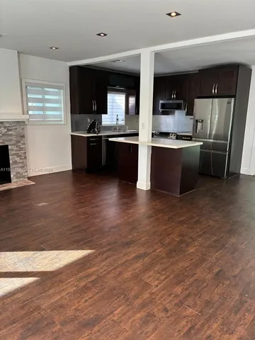 a kitchen with stainless steel appliances kitchen island granite countertop a stove top oven and sink