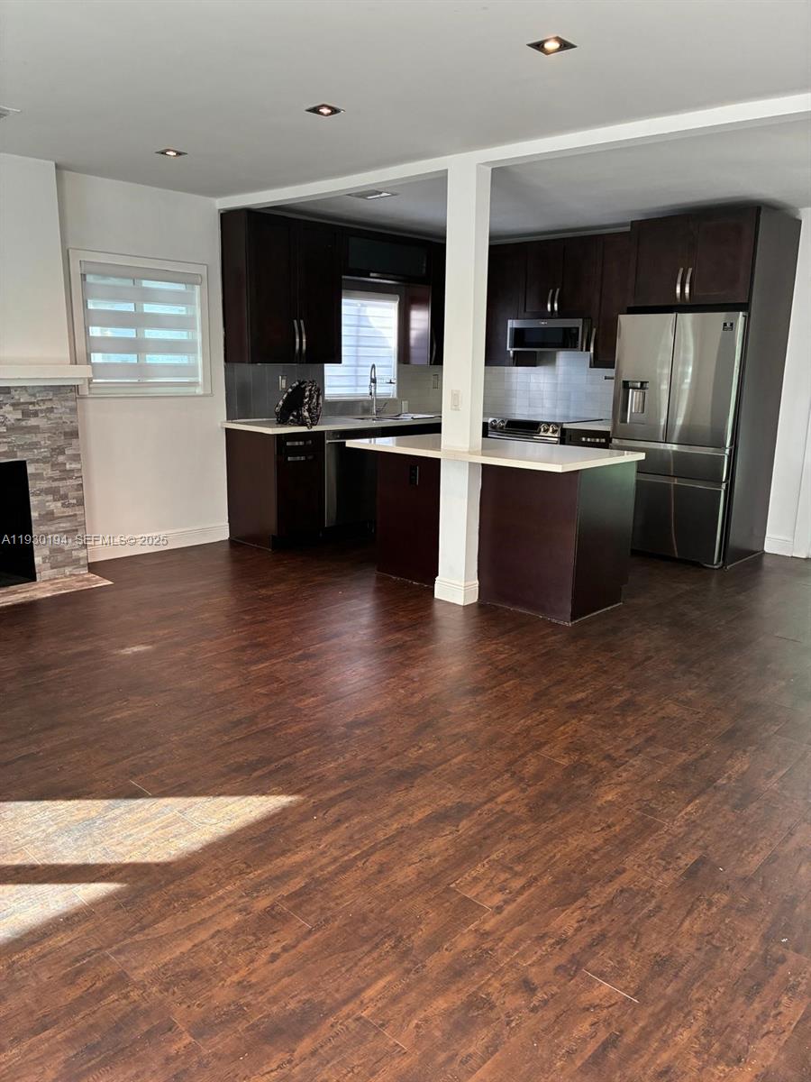 1757 Southwest 24th Terrace Miami, FL 33145 - Photo 11 of 40 a kitchen with stainless steel appliances kitchen island granite countertop a stove top oven and sink