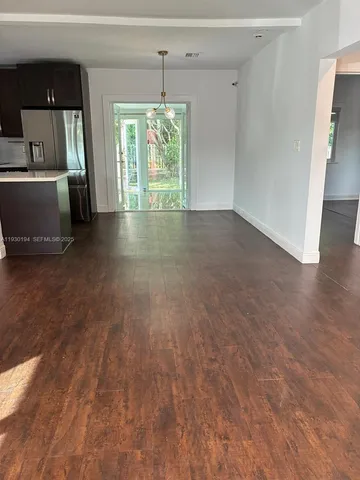 an empty room with wooden floor and window