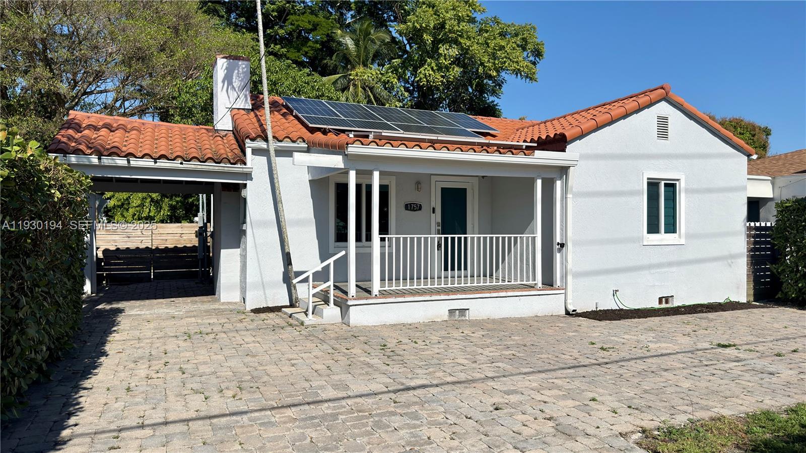 1757 Southwest 24th Terrace Miami, FL 33145 - Photo 2 of 37 a view of a white house with a small yard and large tree