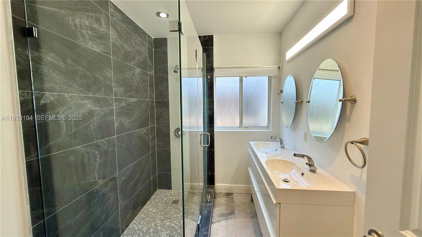 1757 Southwest 24th Terrace Miami, FL 33145 - Photo 23 of 37 a bathroom with a granite countertop sink a mirror and shower