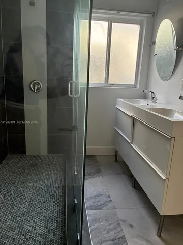 a bathroom with a double vanity sink mirror and shower