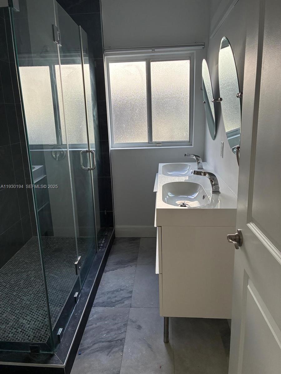 1757 Southwest 24th Terrace Miami, FL 33145 - Photo 28 of 40 a bathroom with a sink a mirror and shower