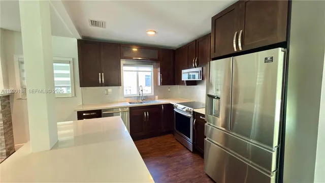 a kitchen with stainless steel appliances a refrigerator sink and cabinets
