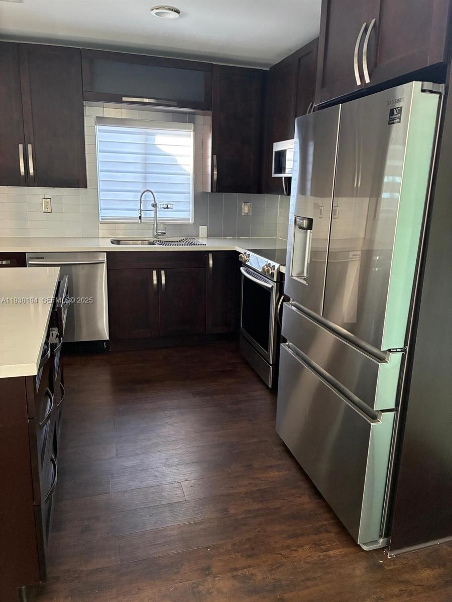 1757 Southwest 24th Terrace Miami, FL 33145 - Photo 8 of 40 a kitchen with stainless steel appliances a refrigerator a sink a stove a microwave and cabinets
