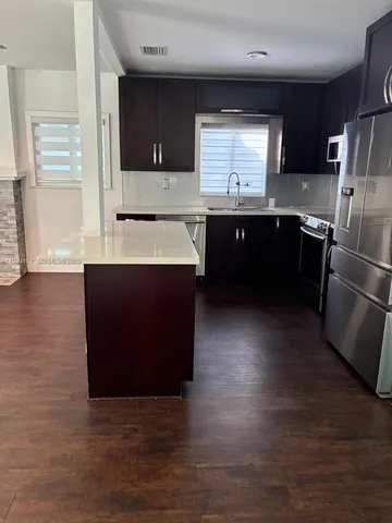 a kitchen with stainless steel appliances wooden cabinets a sink and a stove