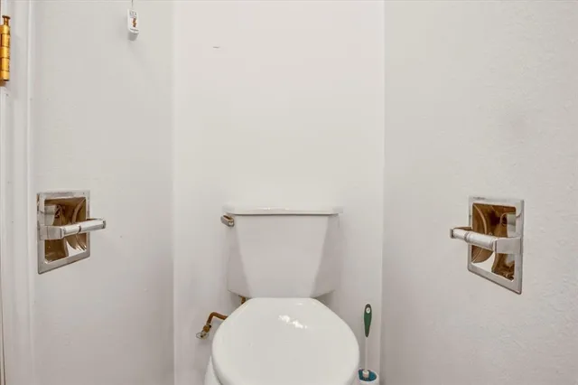 a white toilet sitting next to a white cabinet