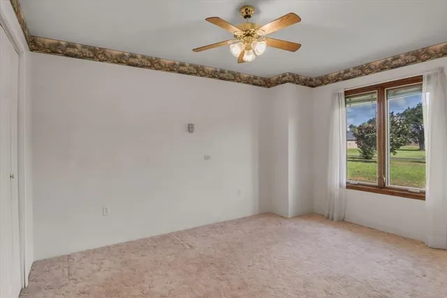 a view of a room with a chandelier fan and windows