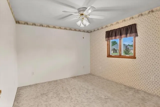 en empty room with windows and fan