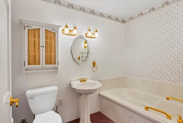 a bathroom with a sink mirror bathtub and toilet