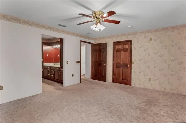 a view of an empty room with a ceiling fan