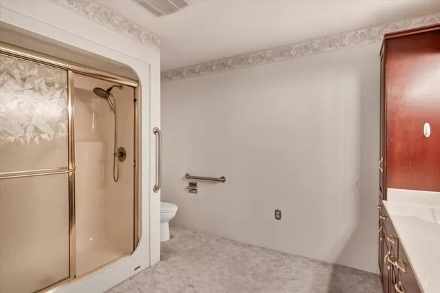 a bathroom with a granite countertop shower and a toilet
