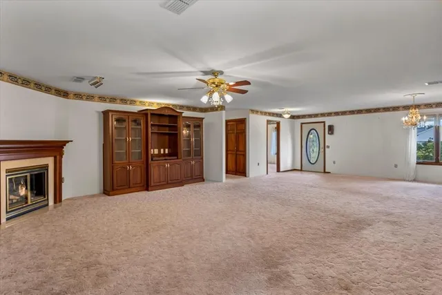 a view of an empty room with a fireplace and a window