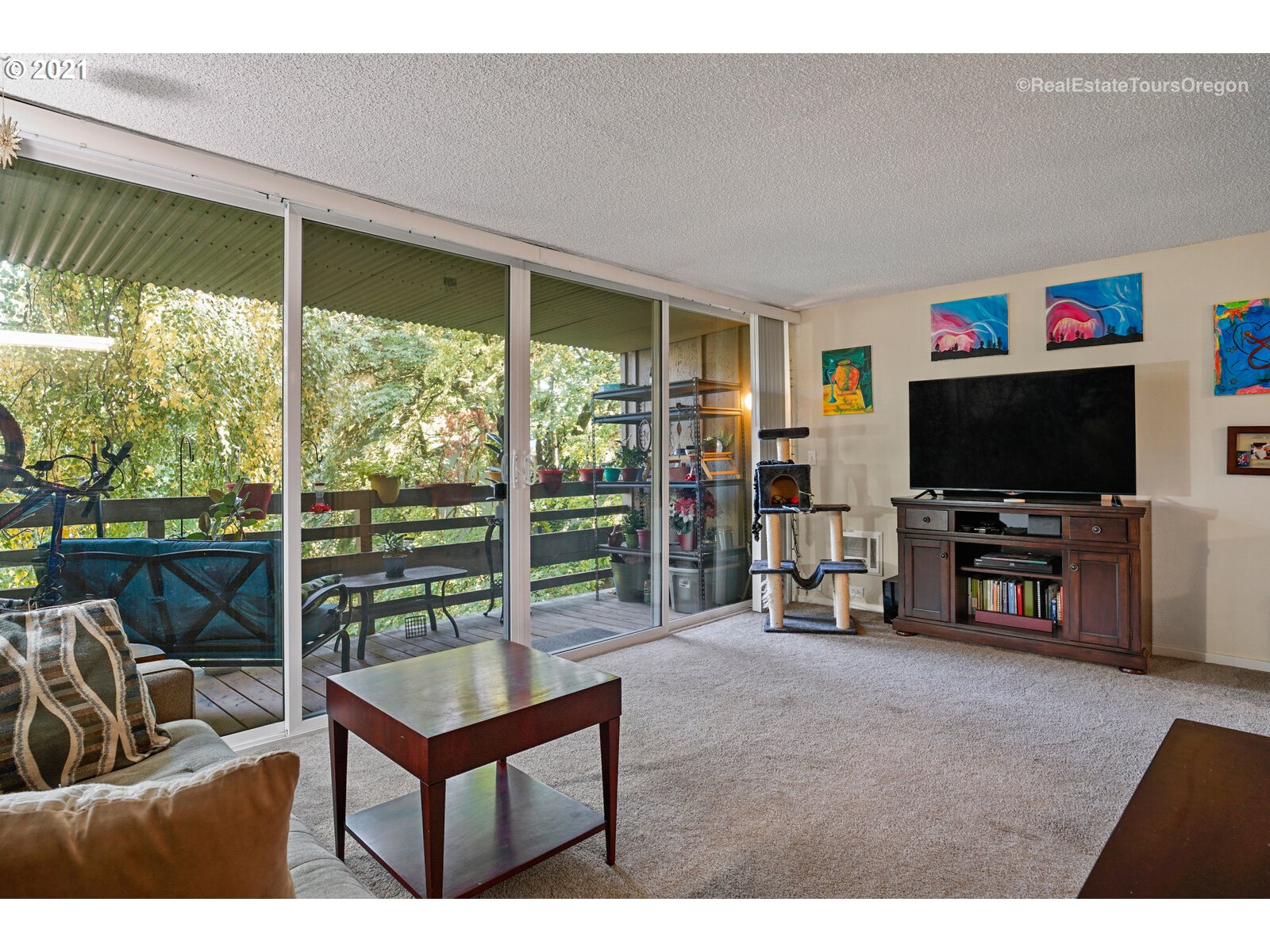 100 Kerr Parkway, Unit 19 Lake Oswego, OR 97035 - Photo 11 of 32 a living room with furniture a flat screen tv and a floor to ceiling window
