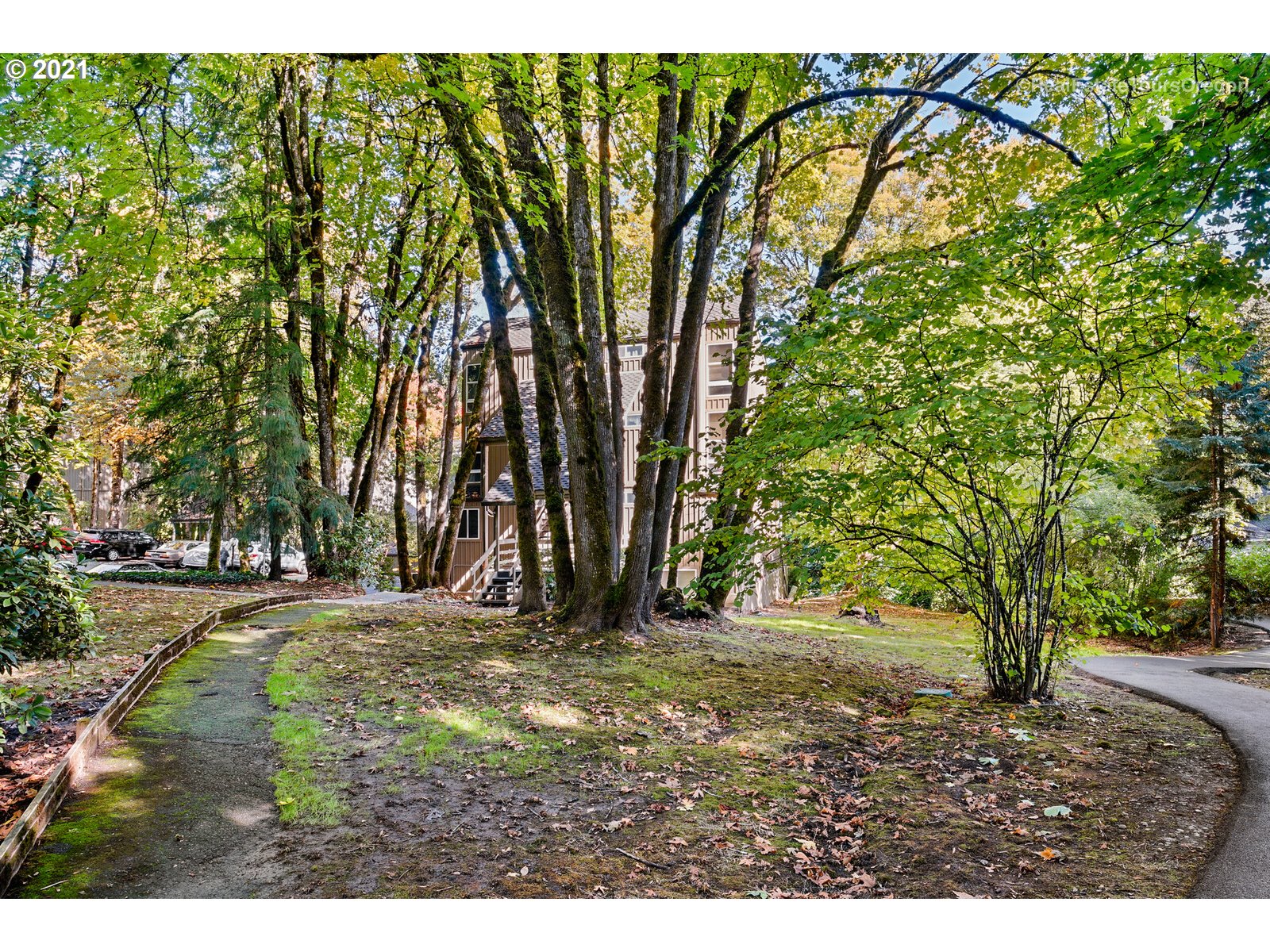 100 Kerr Parkway, Unit 19 Lake Oswego, OR 97035 - Photo 4 of 32 a backyard of a house with large trees and a barn